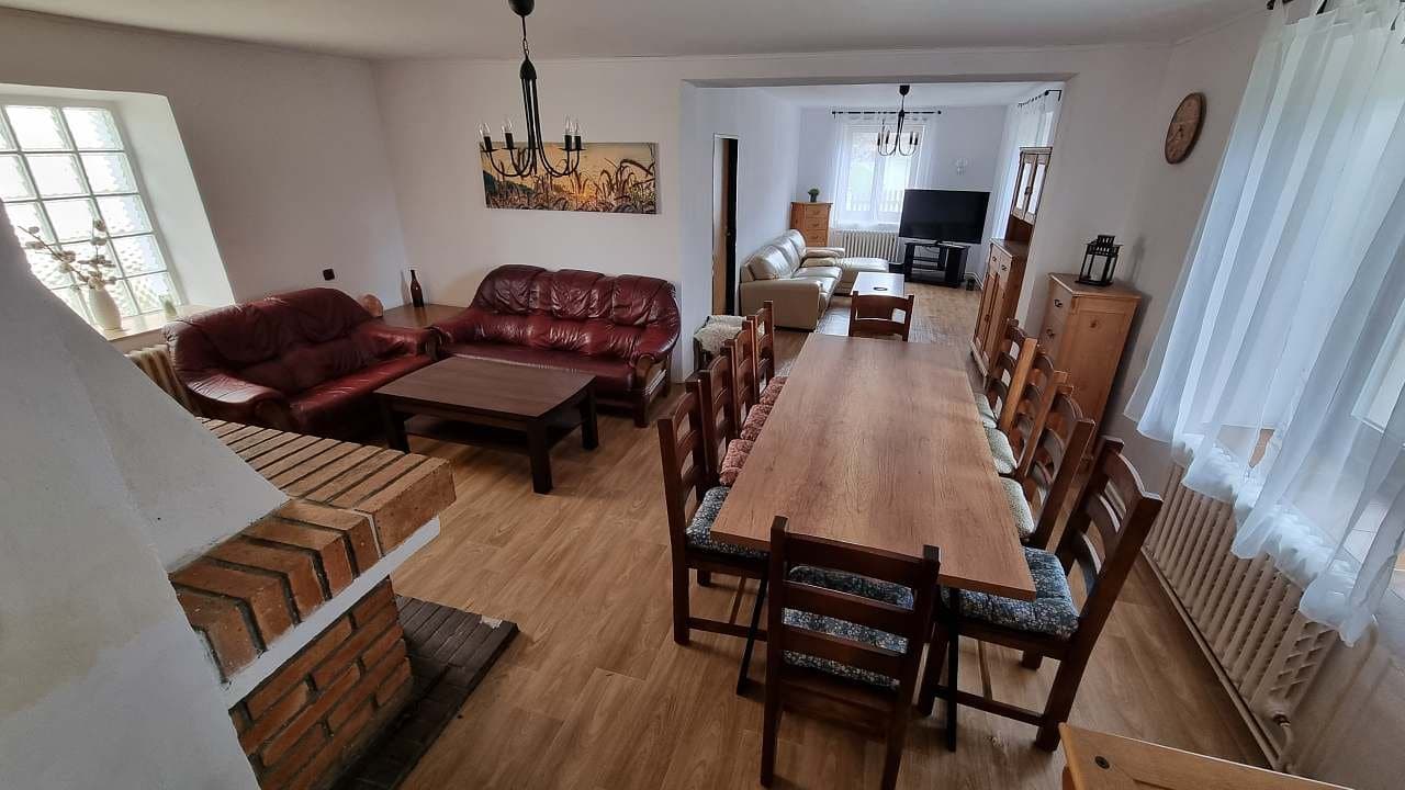 Prostorný obývací pokoj s koženými sedačkami a dlouhým jídelním stolem